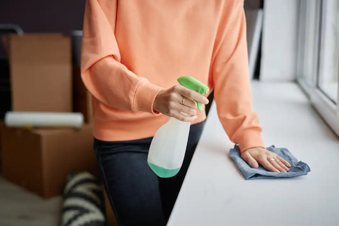 Person applying spray and wiping surface clean, showing efficient deep cleaning and attention to detail.
