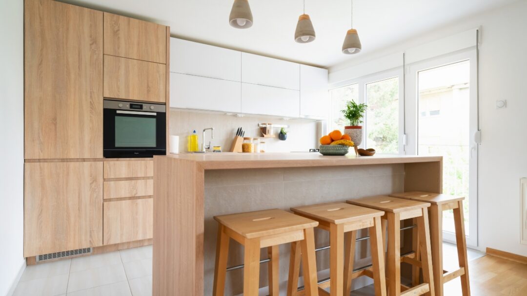 Residential cleaning team maintaining a bright modern kitchen before homeowner arrival.