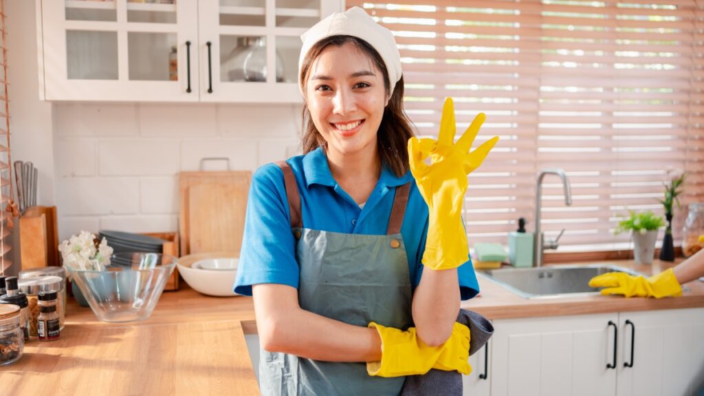 Professional maid service worker in a clean kitchen, completing detailed residential cleaning with quality results.