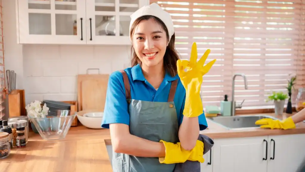 Professional maid service worker in a clean kitchen, completing detailed residential cleaning with quality results.
